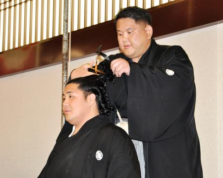 断髪式で師匠の阿武松親方から最後のはさみを入れられる元十両勇磨＝６日、東京・両国国技館