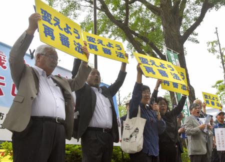 再審制度見直しを巡り、議員への要請活動に参加した（左から）阪原弘次さん、前川彰司さんら＝８日午後、国会前