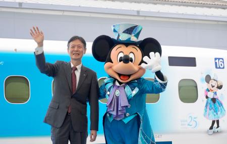 東海道新幹線の特別車両を報道公開し、ミッキーマウスと手を振るＪＲ東海の丹羽俊介社長＝１５日午後、浜松市