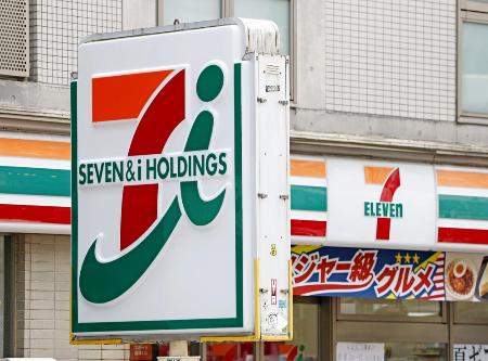 セブン＆アイ・ホールディングスの看板とコンビニ店舗＝昨年７月、東京都新宿区