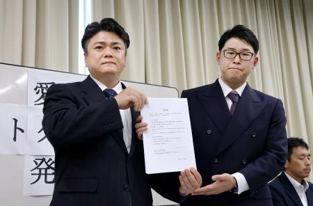 経営者らが署名した誓約書を持つ「愛知県ホストクラブ協議会」の山本洸嗣代表（左）ら＝１８日午後、名古屋市
