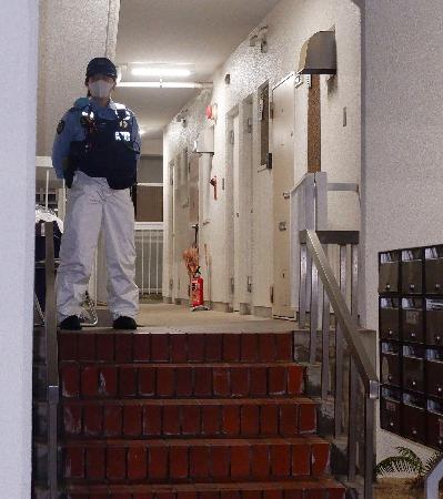 冷凍庫に入った男性の遺体が見つかった集合住宅を警戒する警察官＝２０日午後９時２６分、神戸市中央区