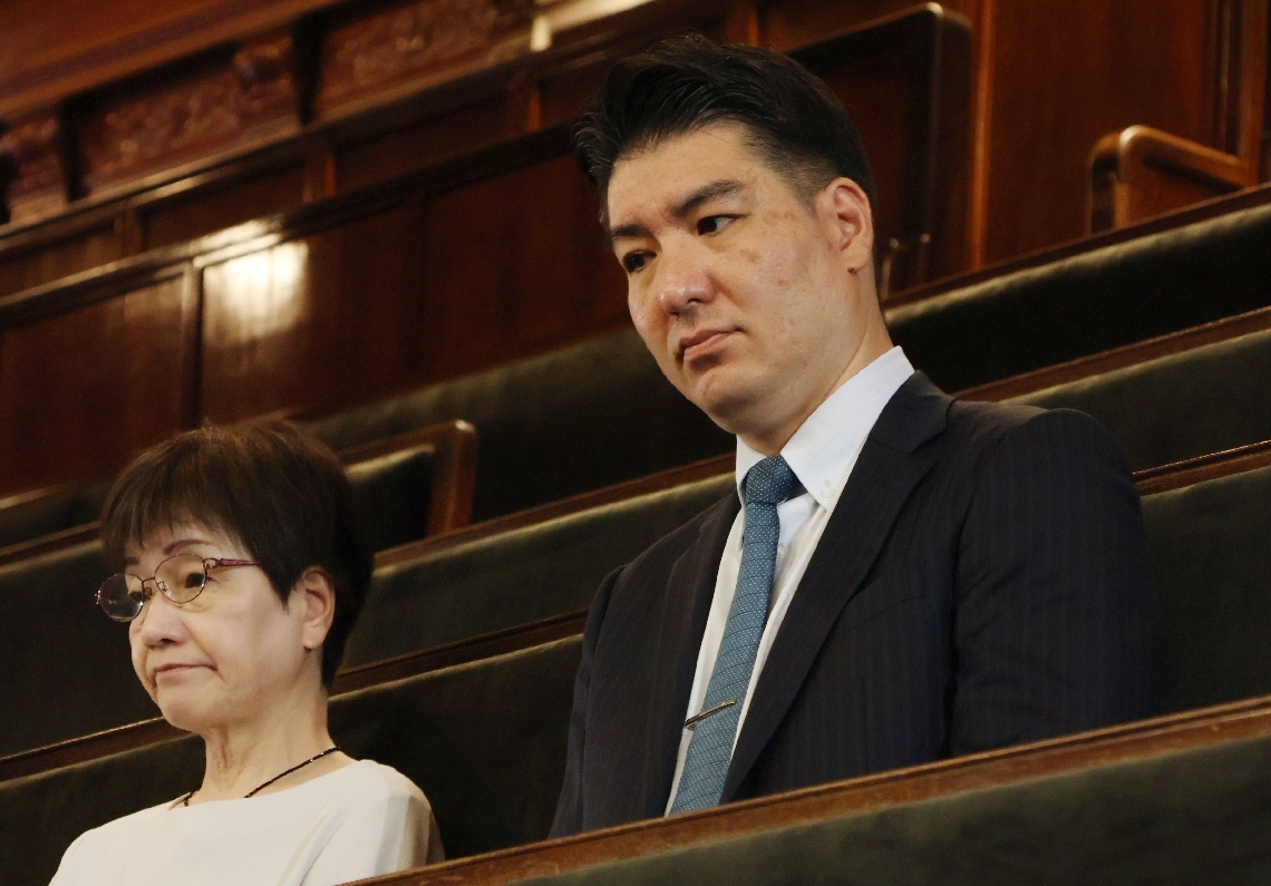衆院本会議で法案成立を見届ける波多野暁生さん（右）。左は津市の時速１４６㌔死亡事故の大西まゆみさん＝２５日、東京・永田町