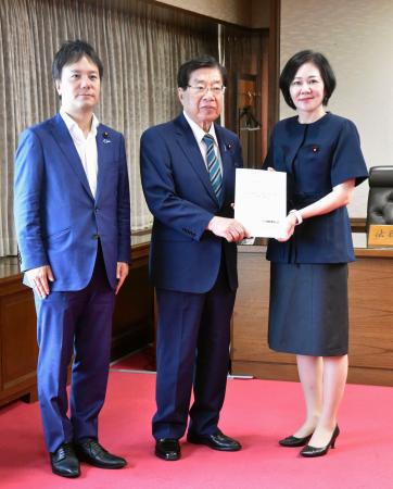 提言を受け取る平口法相（中央）。右は日本維新の会の三木圭恵衆院議員＝２６日午前、法務省