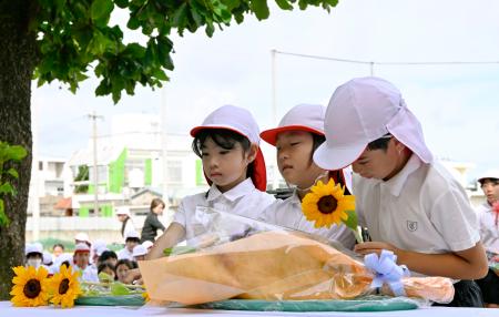 沖縄県うるま市の宮森小で献花する児童たち＝３０日午前