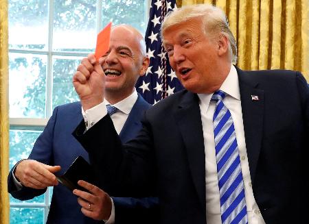 米ホワイトハウスの執務室でレッドカードを手にするトランプ大統領（右）と、国際サッカー連盟（ＦＩＦＡ）のインファンティノ会長＝２０１８年８月（ロイター＝共同）