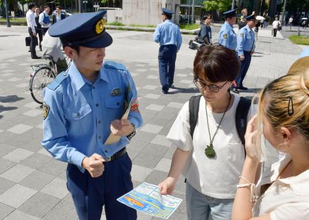 改正小型無人機等飛行禁止法の施行を前に、チラシを配り改正内容を周知する警察官＝８日午後、東京都千代田区