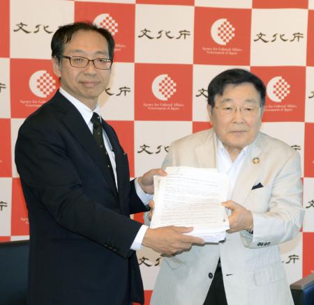 文化庁の松坂浩史審議官（左）に署名を提出する「関西・歌舞伎を愛する会」の堀井良殷代表世話人＝１０日午後、京都市上京区