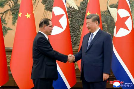 握手する北朝鮮の朴泰成首相（左）と中国の習近平国家主席＝１０日、北京の人民大会堂（朝鮮中央通信＝共同）