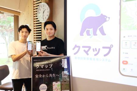 クマの目撃情報をリアルタイムで共有できるスマートフォンアプリ「クマップ」をリリースした「ＢｅａｒＢｅｌｌ」の服部悠大さん（右）＝１３日午後、秋田市の国際教養大