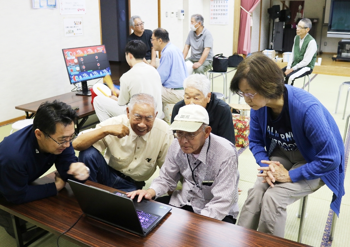 パソコンを囲み「ソリティア」に熱中する参加者ら＝別府市の内竈コミュニティーセンター