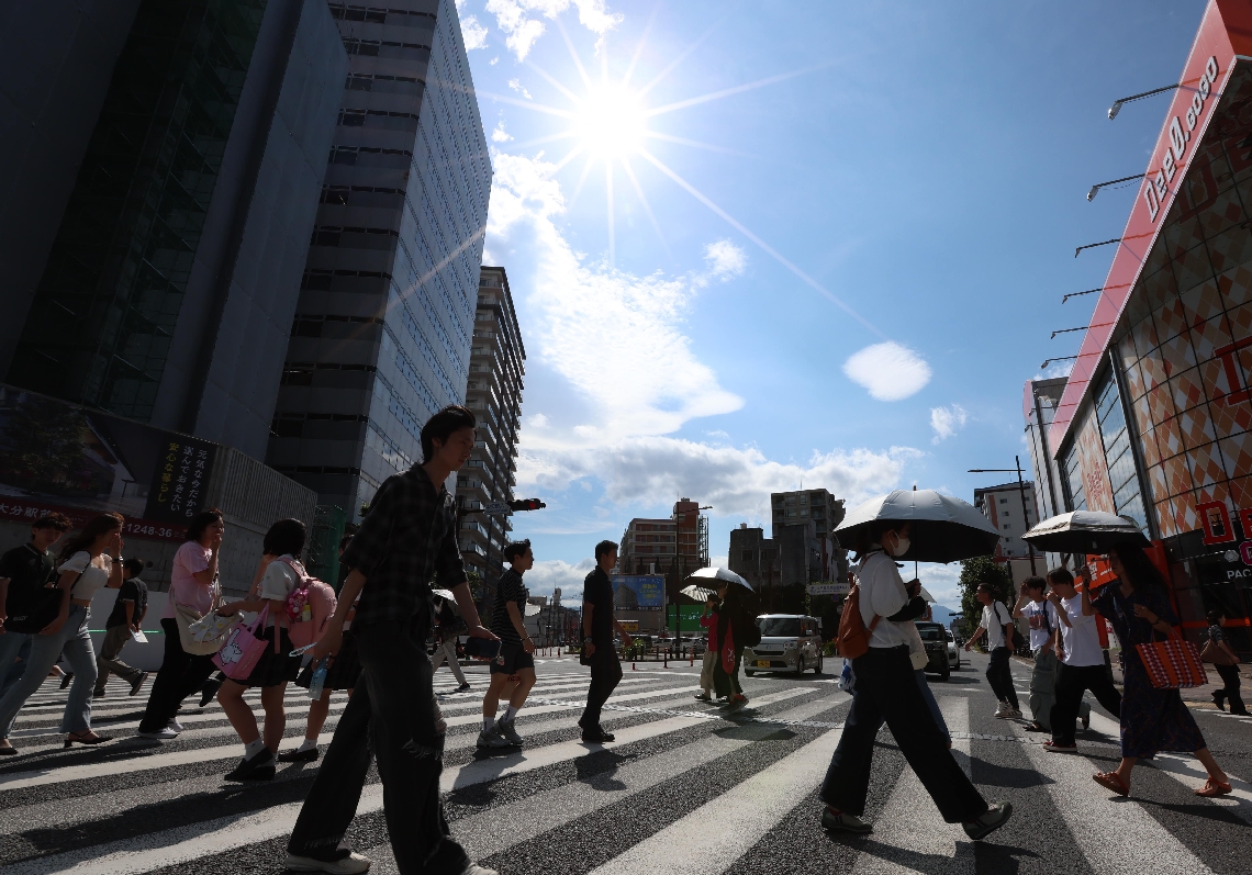 厳しい日差しの下を歩く人たち＝１５日、大分市中央町