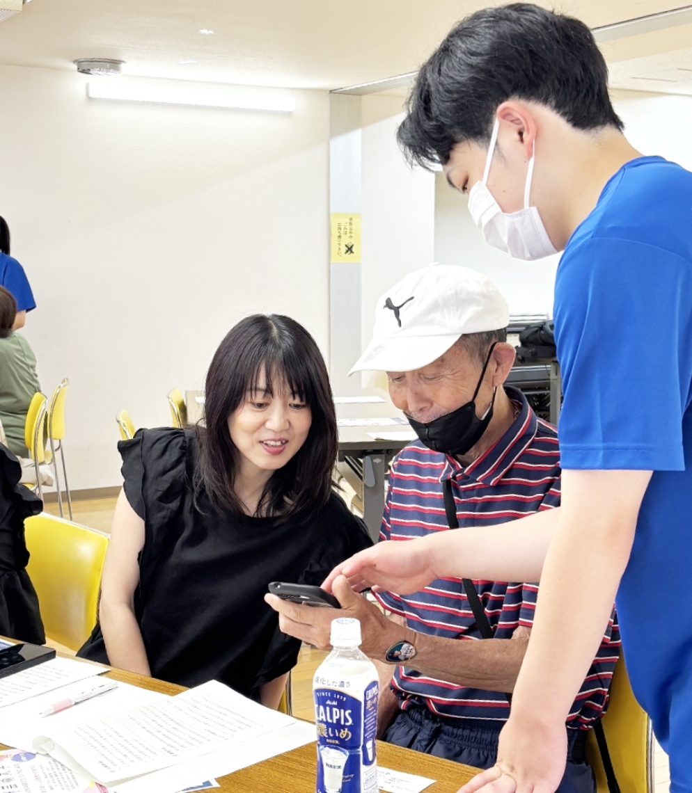 青いＴシャツを着た高校生が受講生をサポート