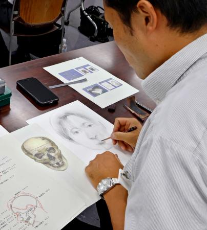 宮城県警本部で開かれた似顔絵作成の講習会で、頭蓋骨の写真をもとに、似顔絵を描く警察官＝２１日午後