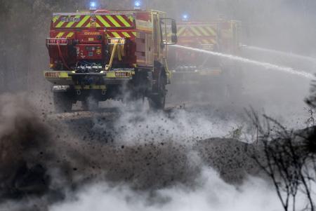 フランス南西部ボルドー近郊で、延焼防止のため放水作業をする消防車＝２７日（ロイター＝共同）