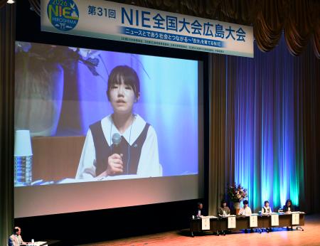 スクリーンに映し出された、ＮＩＥ全国大会で発言する山田弥栄子さん＝３０日午後、広島市