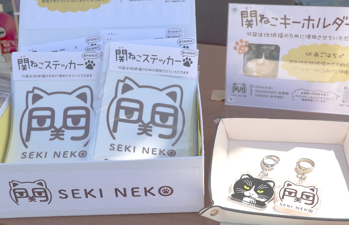 地域猫をモチーフにしたキーホルダーと「関ねこ」のロゴマークのステッカー