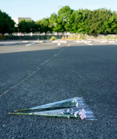 「イオンモール熊本」前の駐車場に供えられた花束＝３１日午前６時４２分、熊本県嘉島町