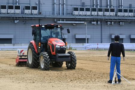 進行方向に人や障害物を検知すると自動で緊急停止する無人自動運転トラクター＝６日午前、堺市