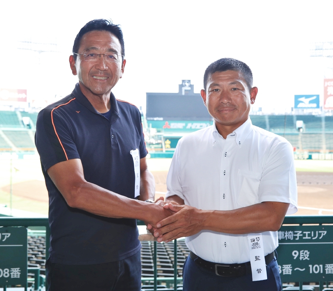 握手を交わす大分商の那賀誠監督（左）と日本文理の鈴木崇監督＝甲子園球場