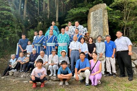 横綱阿武松の石碑の前で記念撮影する阿武松部屋の力士と地元住民＝１１日、石川県能登町