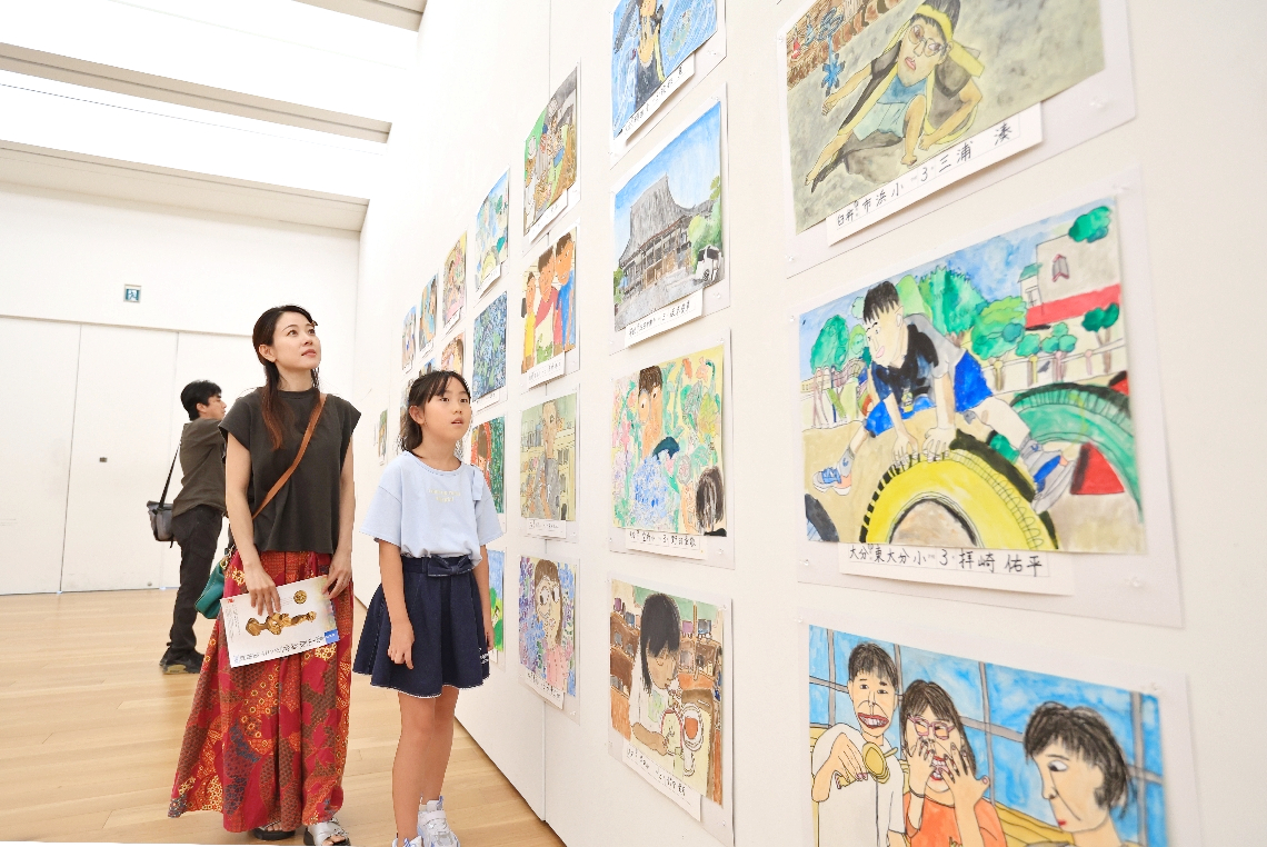 展示作品を鑑賞する親子連れ＝２２日、大分市寿町の県立美術館