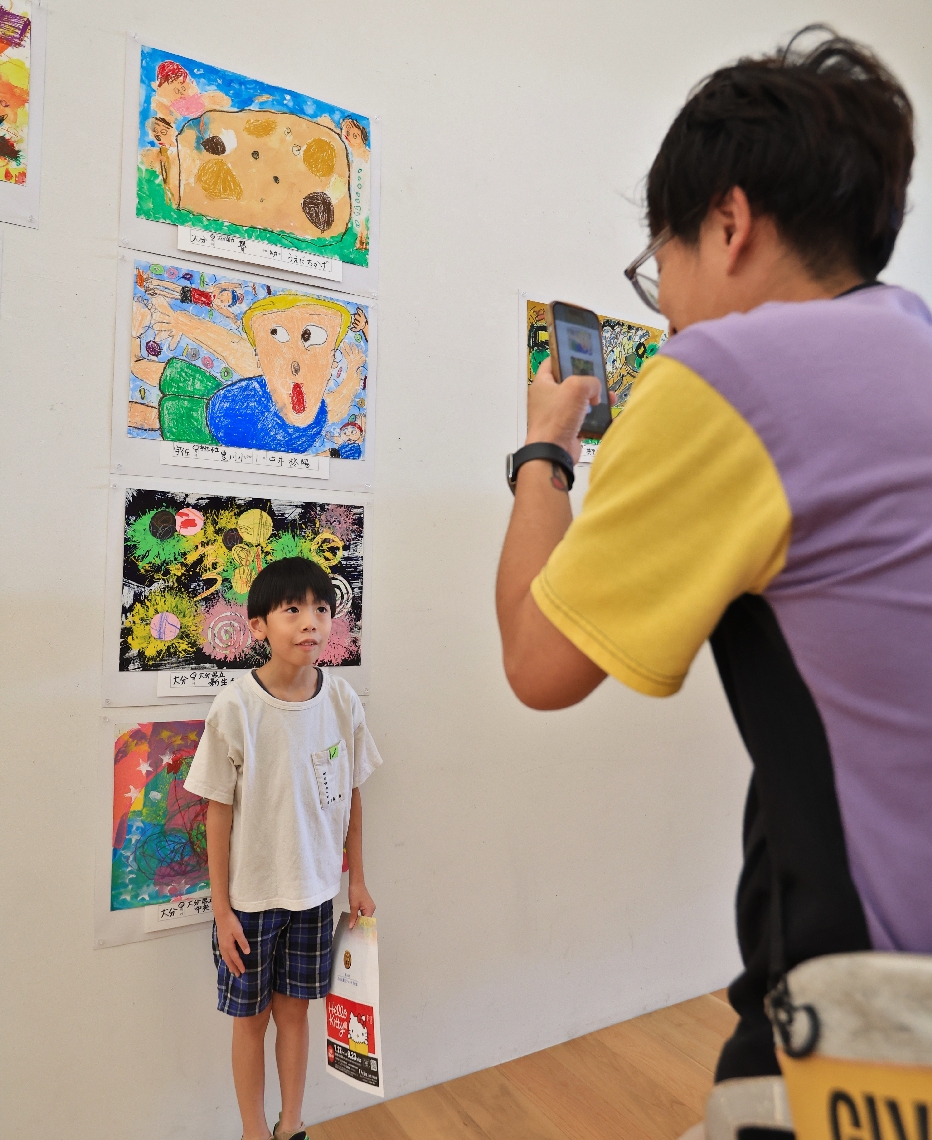 作品の前で記念撮影をする親子連れ