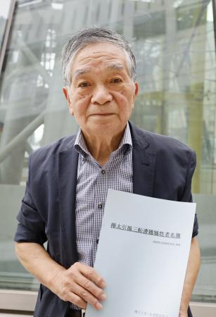 「三船遭難事件」の犠牲者名簿を手にする中尾則幸さん＝７月、札幌市
