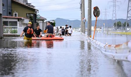 大雨で冠水した福井県坂井市内の道路。住民らがボートに乗り、必要物資の買い出しに向かっていた＝３０日午後２時４４分