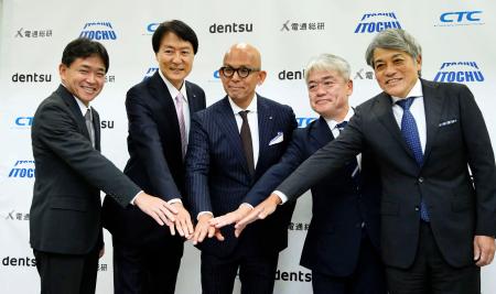 写真に納まる伊藤忠商事と電通総研の関係者ら＝３１日午後、東京都内