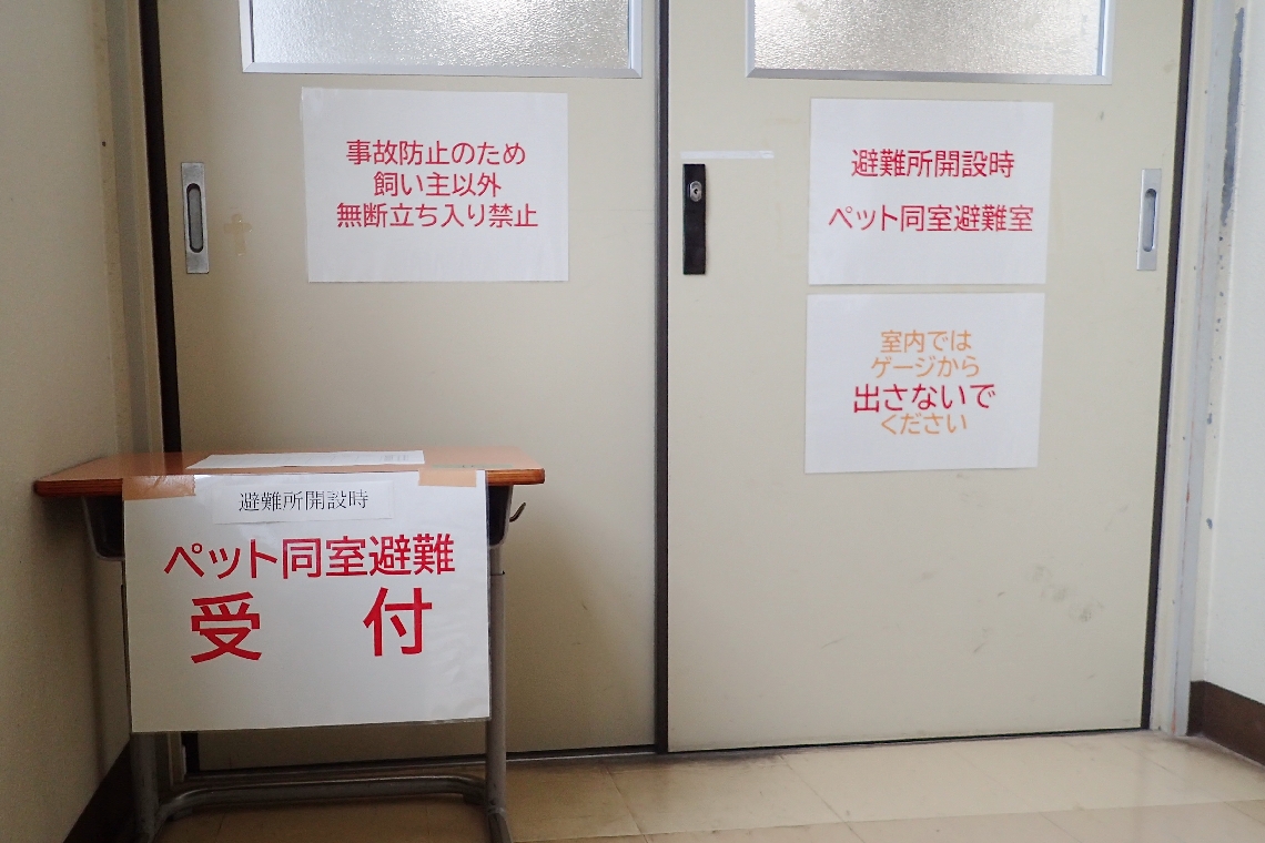 教室の入り口には、避難所を示す張り紙や受付がある
