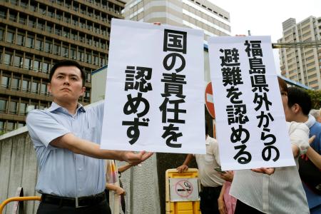 大阪地裁の判決を受け、「国の責任を認めず」などと書かれた垂れ幕を掲げる原告側弁護団＝２日午前、大阪市北区