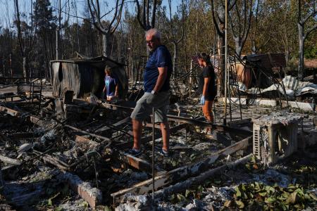 スペイン・マドリード近郊の山火事、焼けたキャンプ場から持ち物を探す人たち＝７月（ＡＰ＝共同）