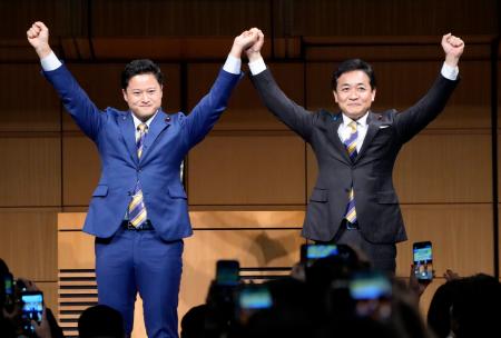 国民民主党の代表選で３選を決め、橋本幹彦衆院議員（左）と手を取り合う玉木雄一郎代表＝６日午後、東京都千代田区