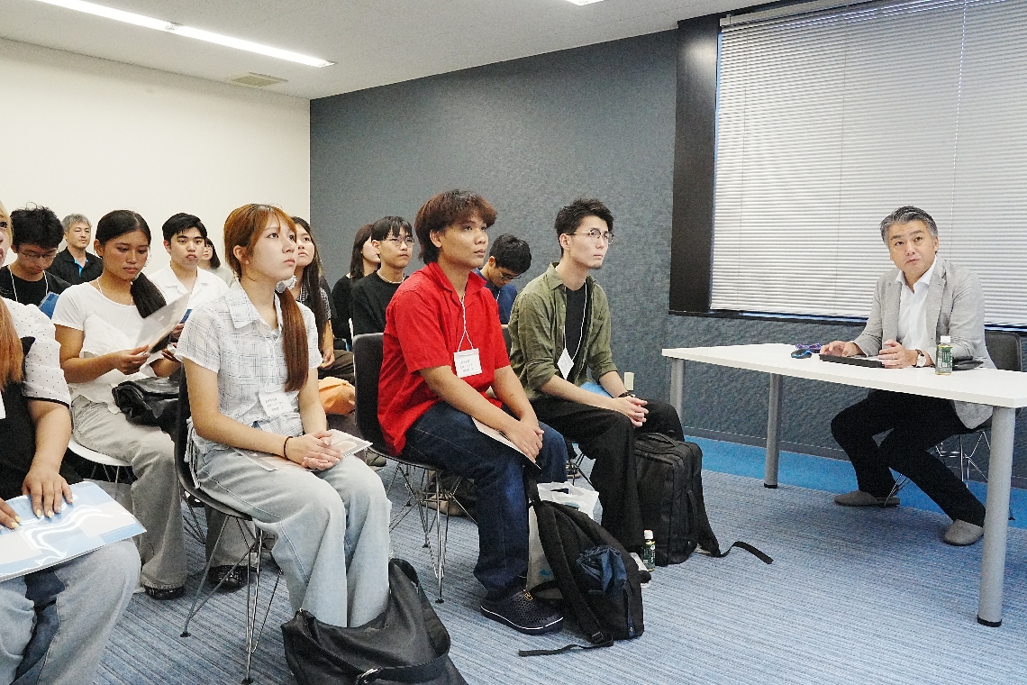 地元企業の代表者（右端）から業務内容などを聞くバスツアーの大学生ら＝日田市中央