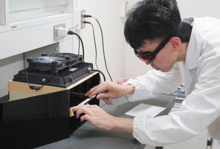 鮮やかな「白色」の材料を印刷する技術を実演する研究チーム員＝９日午後、京都市