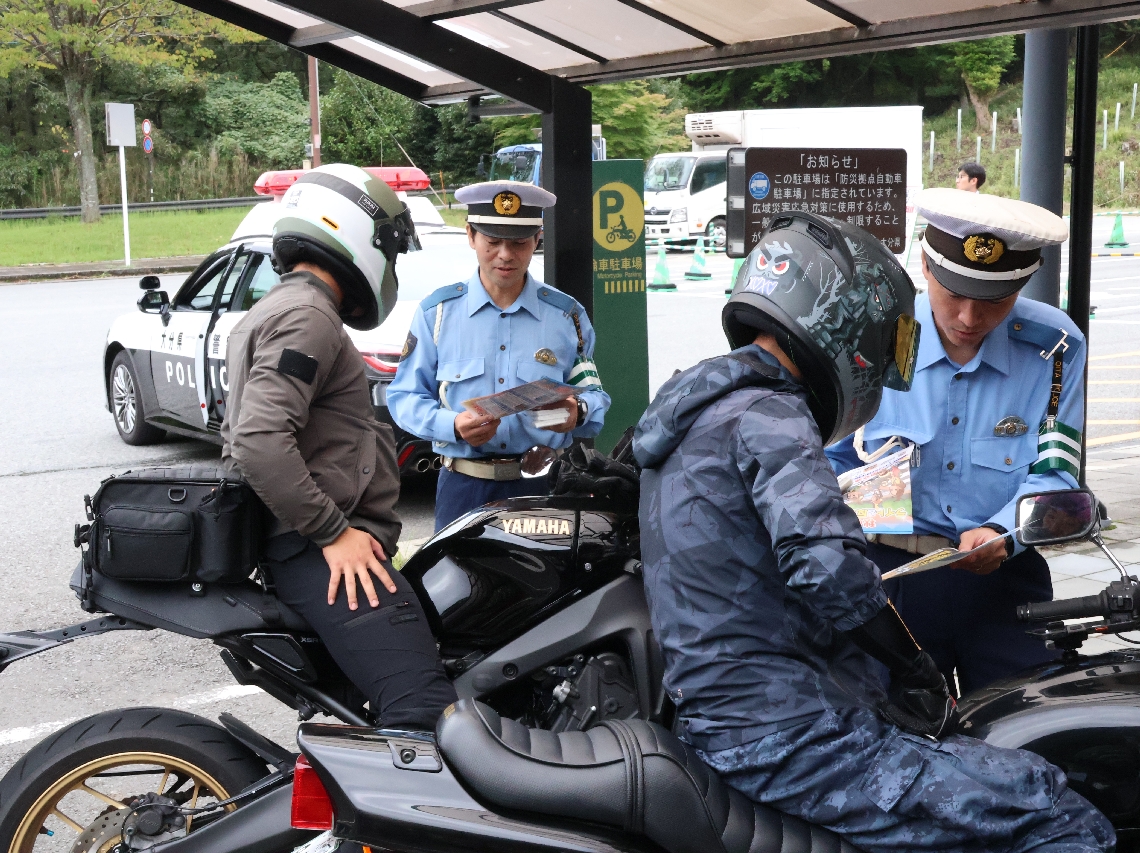 バイクの安全運転を呼びかける署員ら＝１４日、由布市湯布院町川北