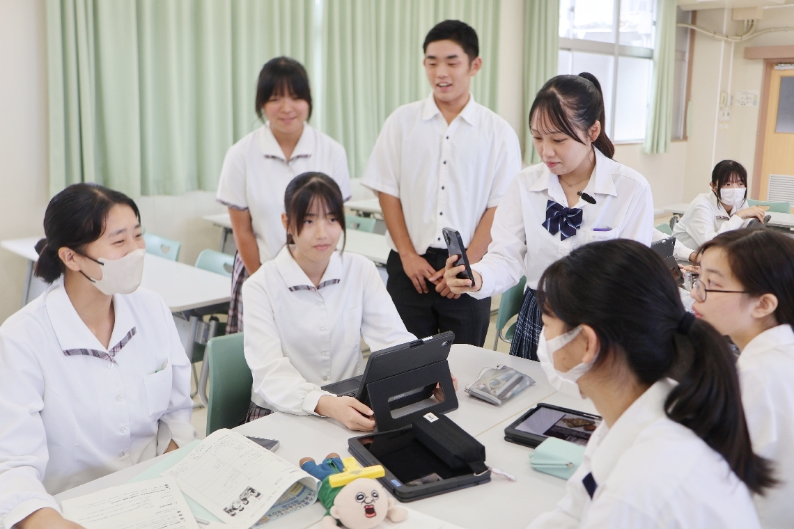 話し合いをするギフト班の生徒と、様子を撮影するＳＮＳ班の生徒＝津久見高