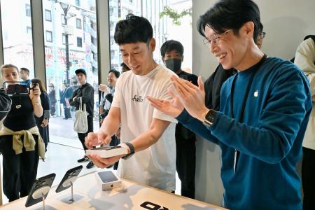 「ｉＰｈｏｎｅ１８プロ」を購入する男性（左）＝１８日午前、東京都中央区の「アップル銀座」