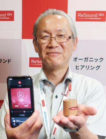 無線通信「オーラキャスト」に対応した補聴器を紹介する理研産業の桜井雅之取締役＝７月、愛知県みよし市