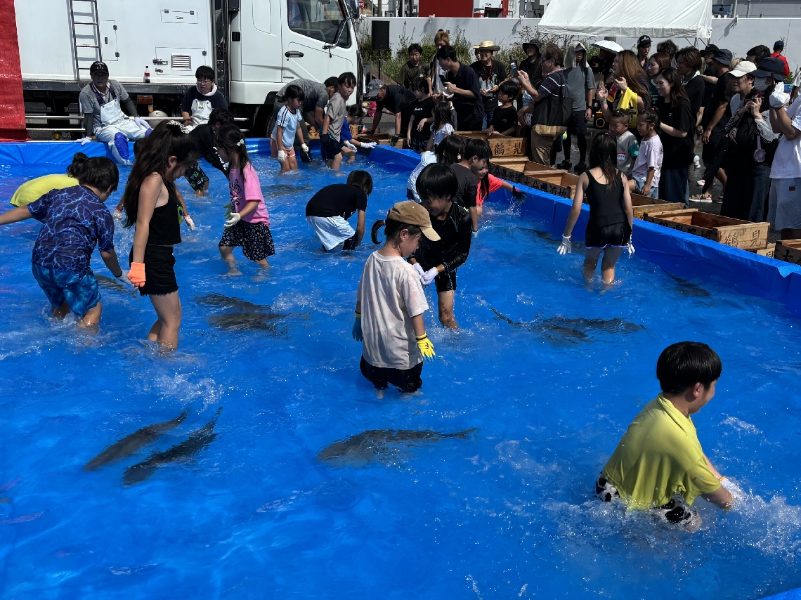 特設プールで魚のつかみ取り＝１９日、佐伯市