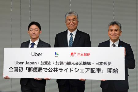 記者会見で写真に納まる石川県加賀市の山田利明市長（中央）ら＝２９日午後、東京都内