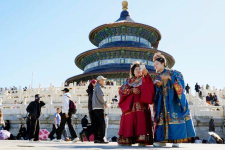 北京の天壇公園で漢族の伝統衣装「漢服」を着て写真を撮る女性たち＝１日（共同）