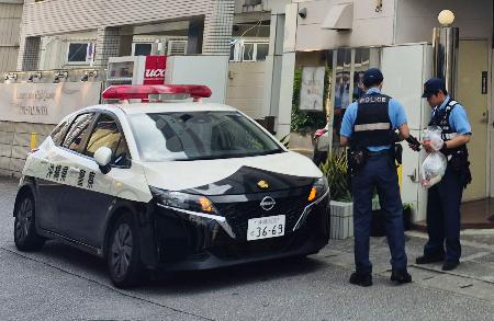 女性の遺体が見つかった現場周辺で捜査を続ける警察官ら＝４日午前、那覇市