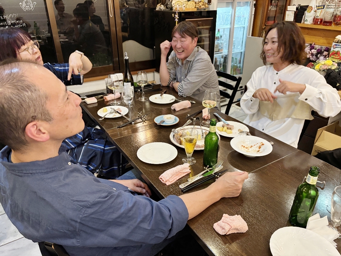 談笑する中西さんと食事会参加者たち＝３日、大分市