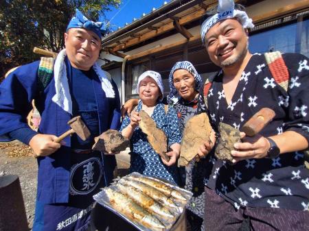 石炭でサンマを焼く催しを企画した江尻浩二郎さん（左端）と住民の志賀喜美子さん（左から２人目）ら参加者＝８日午前、福島県いわき市