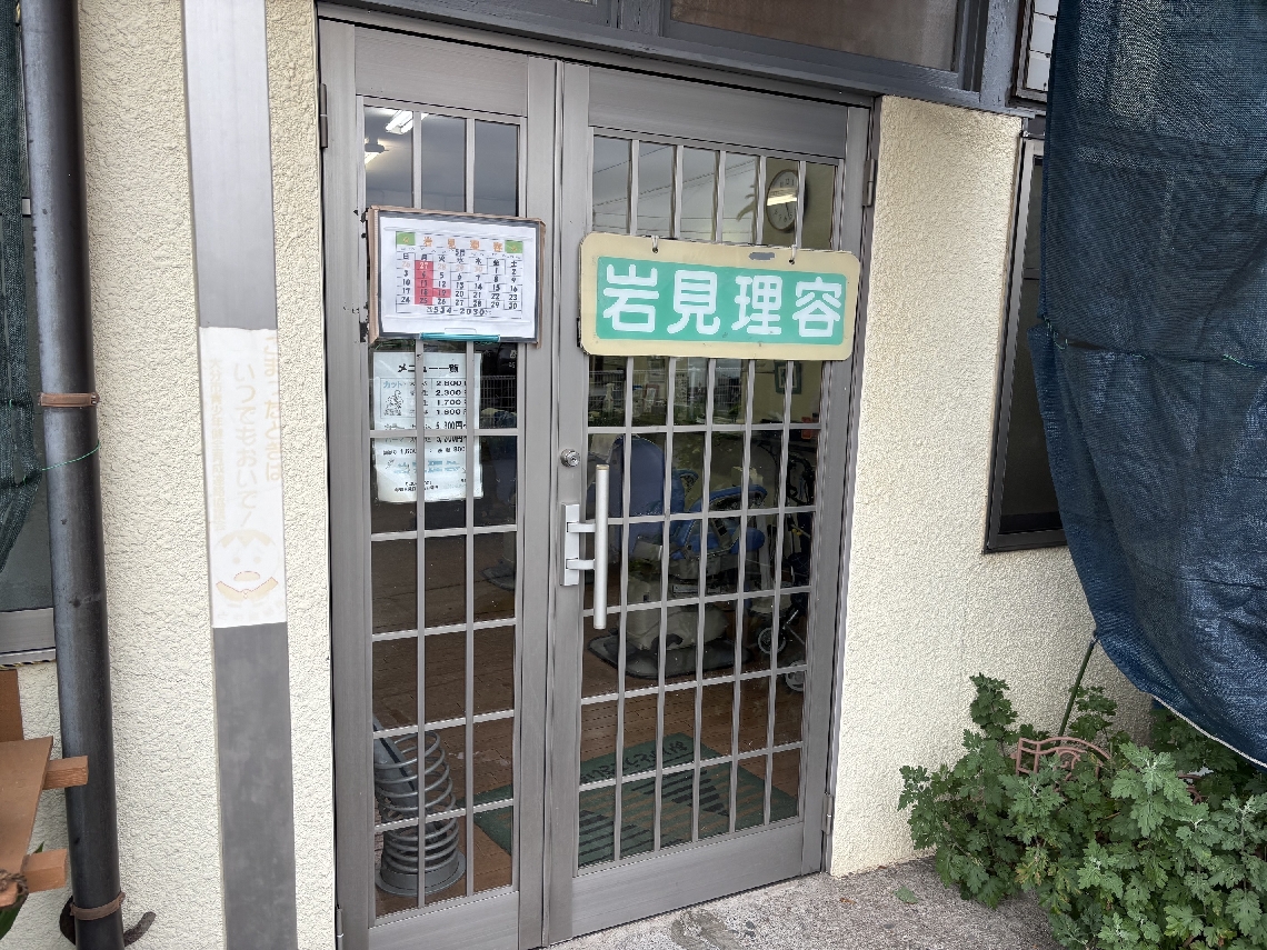 大分交通の合同庁舎前稲荷バス停横の岩見理容＝大分市新川町