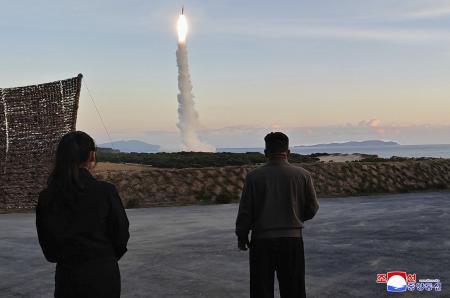 ３日、北朝鮮東部で行われた中距離戦略ミサイルの発射訓練を視察する金正恩朝鮮労働党総書記（右）と娘（朝鮮通信＝共同）