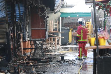 全焼した市場「マルシェ・デ・ザンファン・ルージュ」で消火活動に当たる消防士＝１２日、パリ（共同）