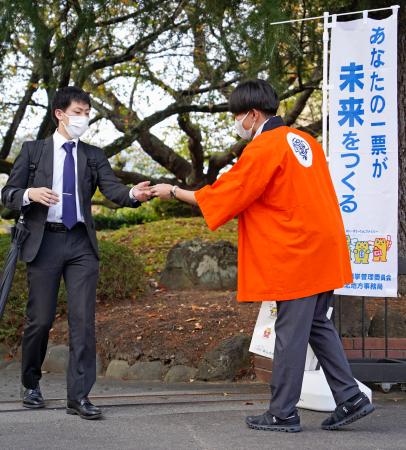 福島県知事選の投票を呼びかける県選挙管理委の職員（右）＝１４日午前、福島市